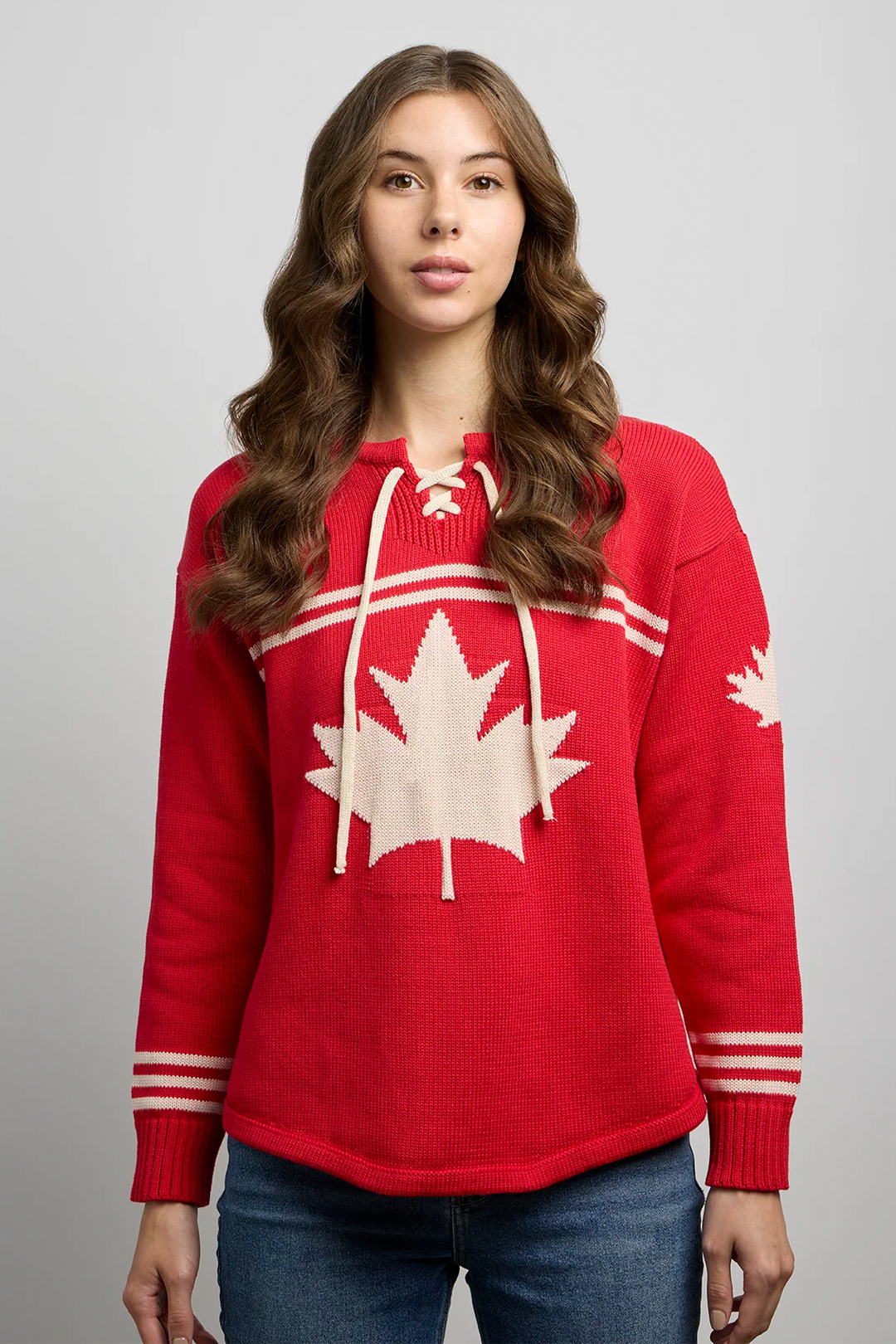 A woman modelling a red hockey jersey style sweater with a large maple leaf on the front. 