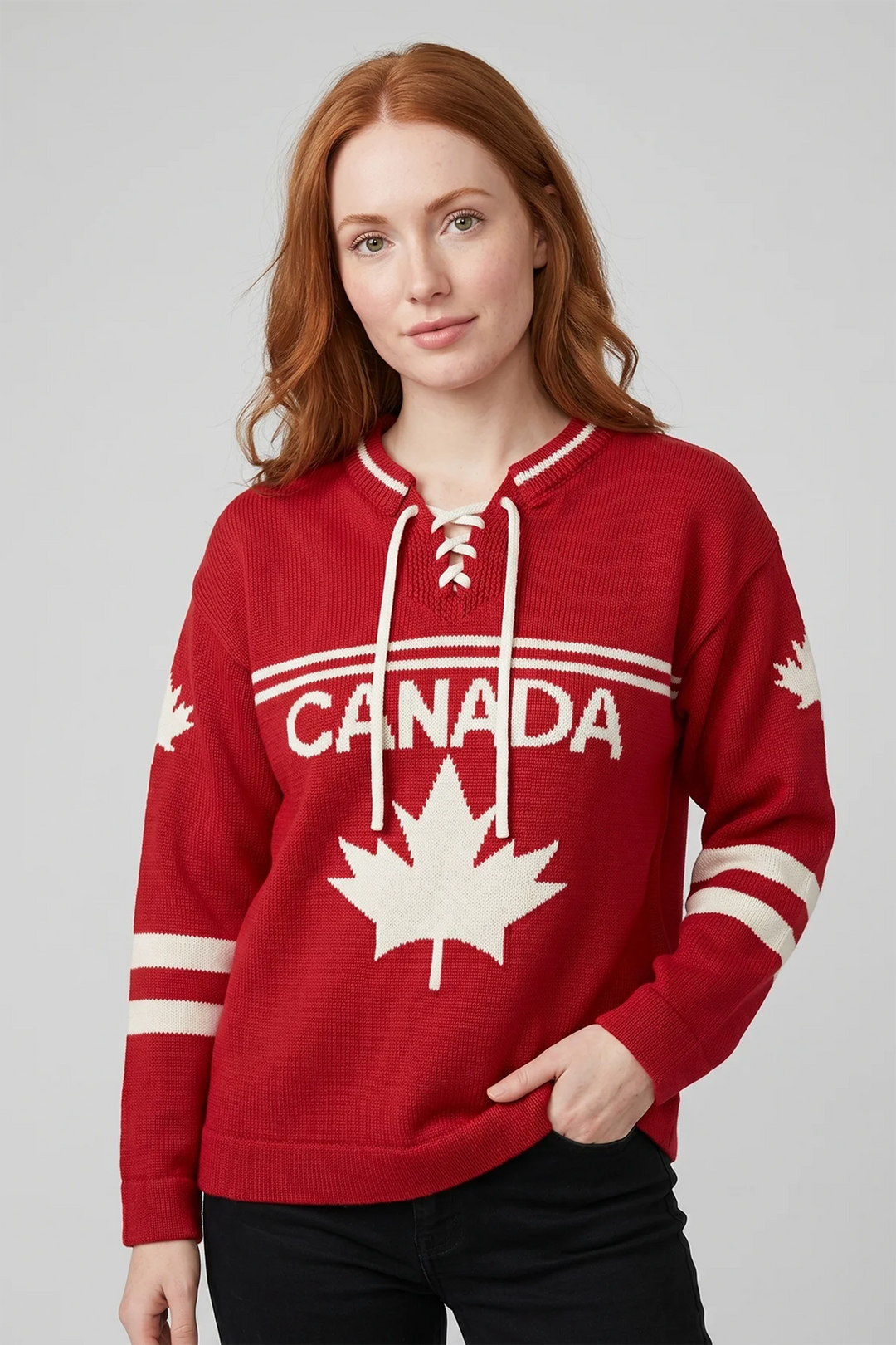 A woman modelling a red hockey jersey style sweater with stripes across the front with a large Canada and maple leaf emblem on the front. 