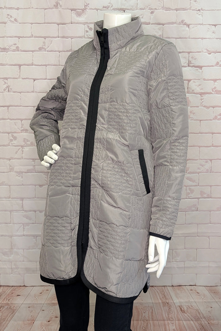 Gray quilted jacket with black accents on a mannequin against a white brick wall.