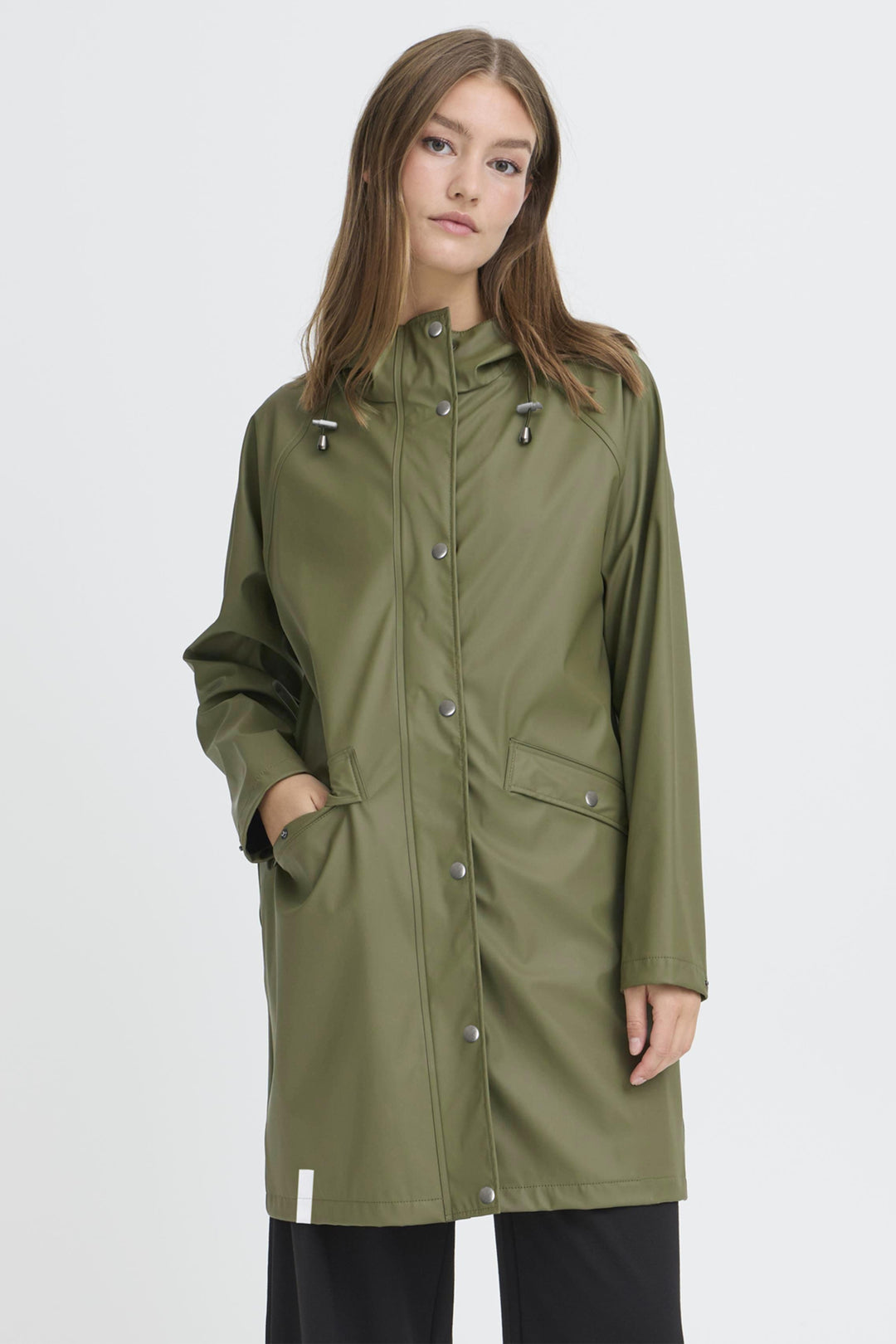 Woman wearing a green raincoat on a white background