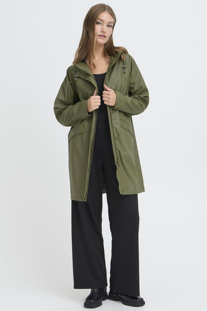 Woman wearing a green coat on a white background