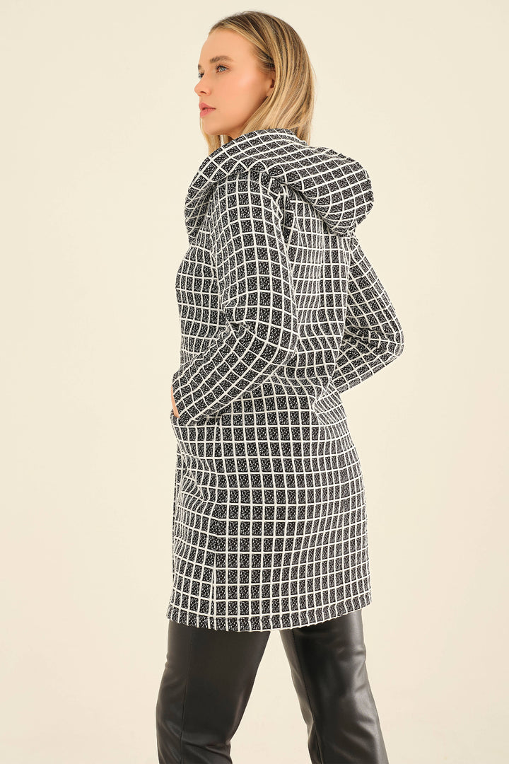 Woman wearing a black and white checkered raincoat on a beige background