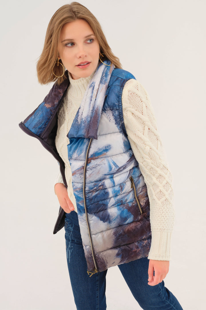 Woman wearing a patterned puffer vest over a white sweater on a white background