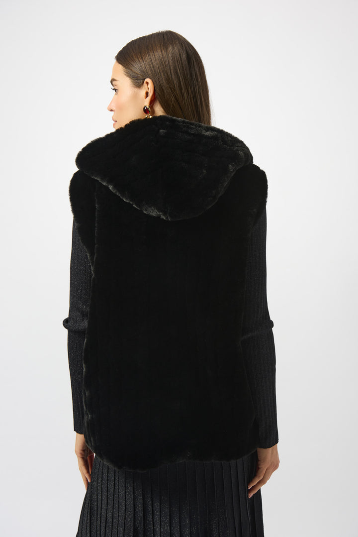 Woman wearing a black fur-trimmed coat on a white background