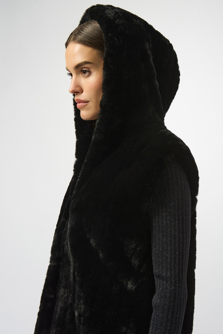 Person wearing a black hooded coat on a white background