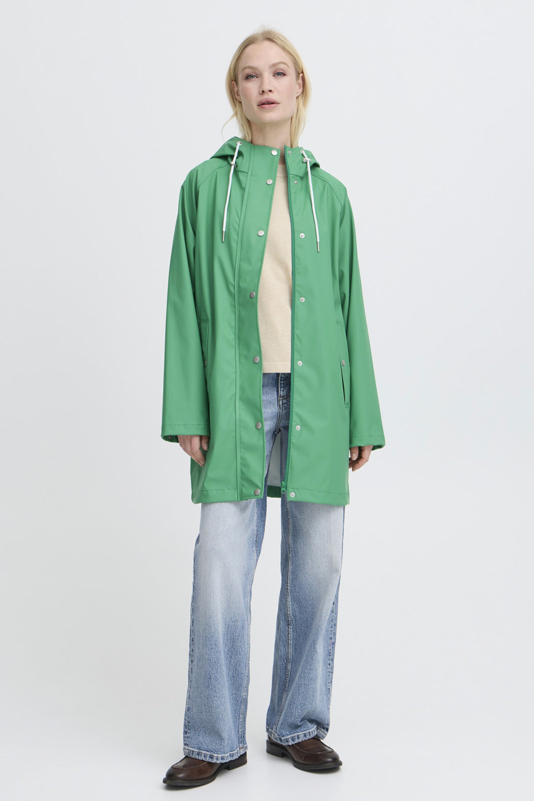 Person wearing a green raincoat on a white background