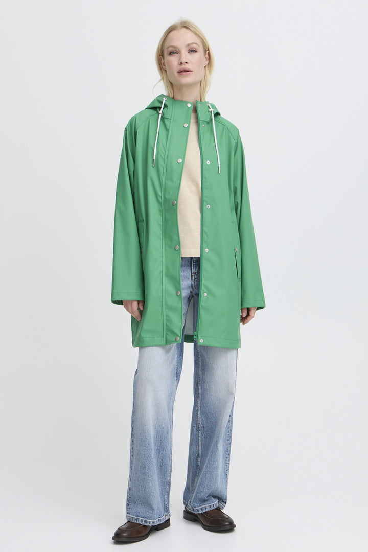 Person wearing a green raincoat on a white background