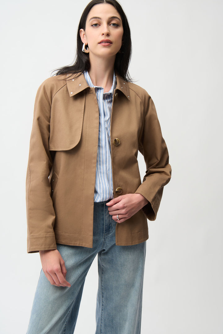 A woman modelling a short brown trench coat and jeans. 