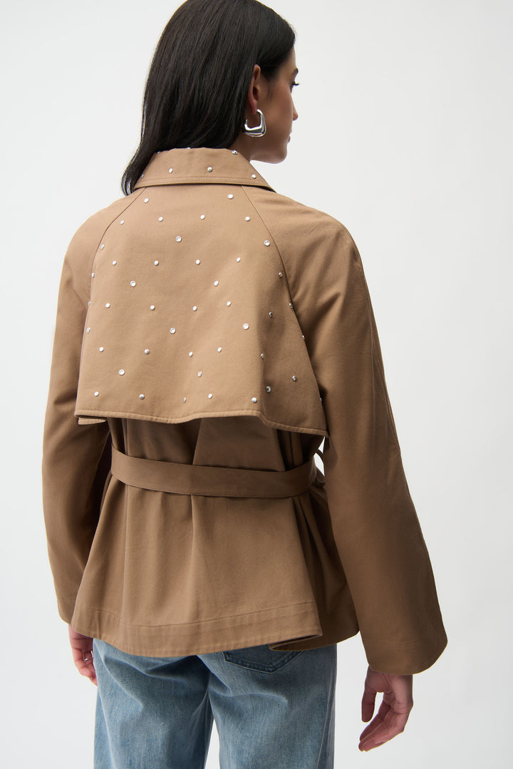 A woman modelling a short brown trench coat and jeans. 