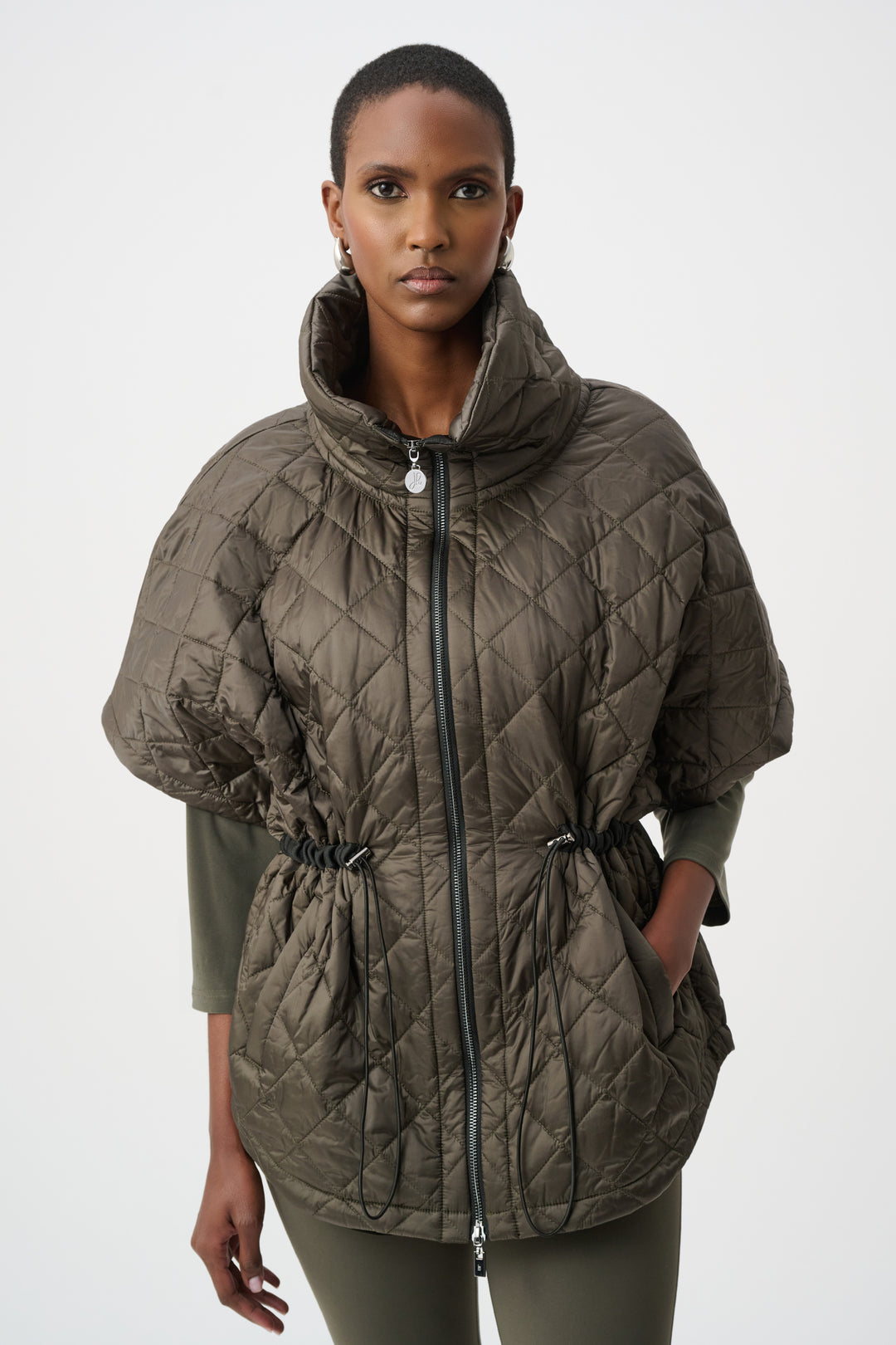 Woman wearing a quilted green vest coat on a white background
