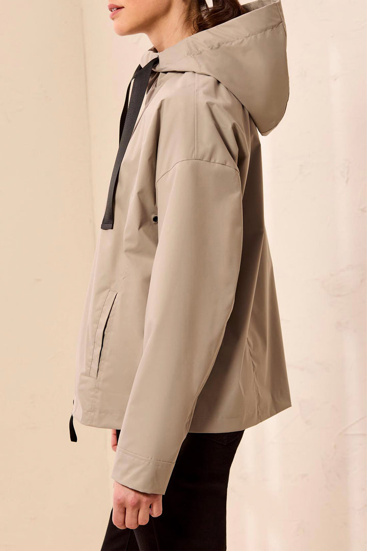 Beige hooded jacket worn by a person on a beige background