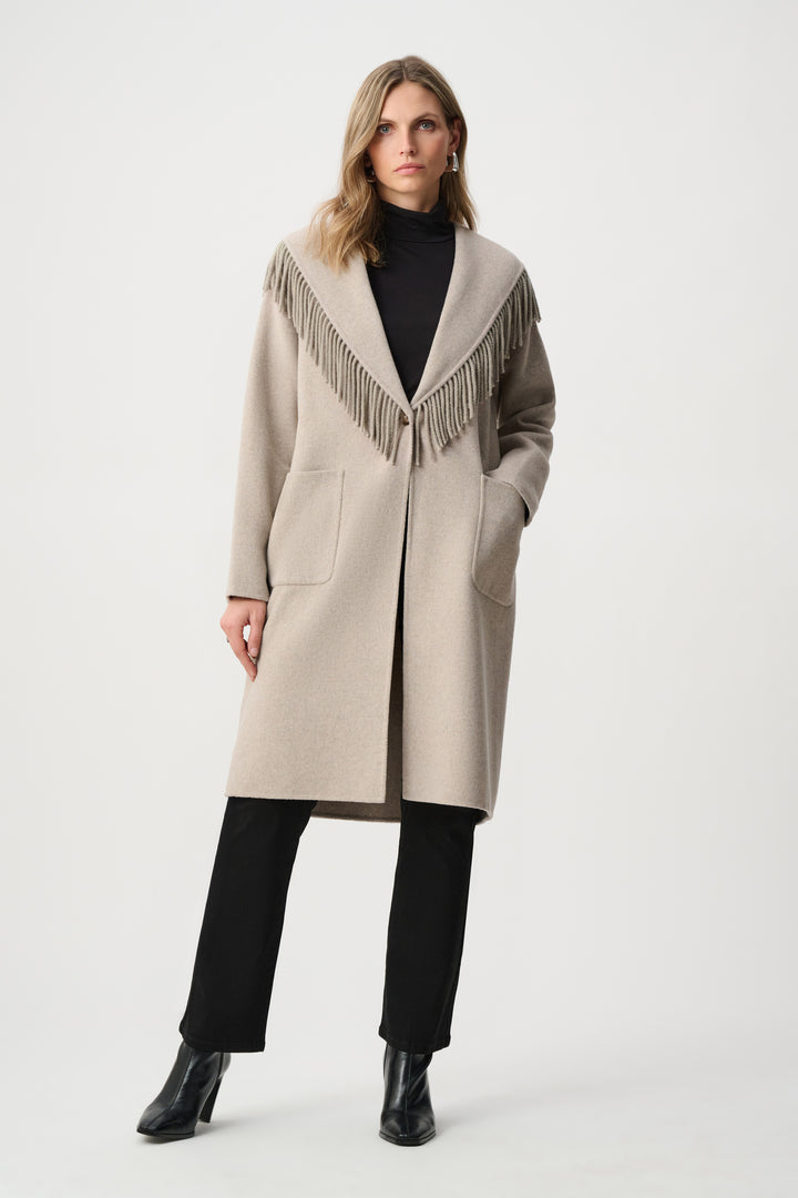 Woman wearing a beige coat with fringe details on a white background