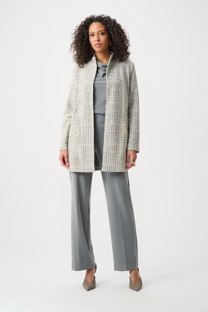 Woman wearing a checkered blazer over a gray top and pants on a white background