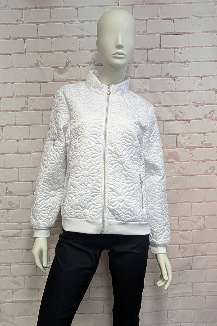 A mannequin wearing a white quilted zip-up jacket with a stand-up collar, ribbed cuffs and hem, and zippered hand pockets, shown against a brick background.