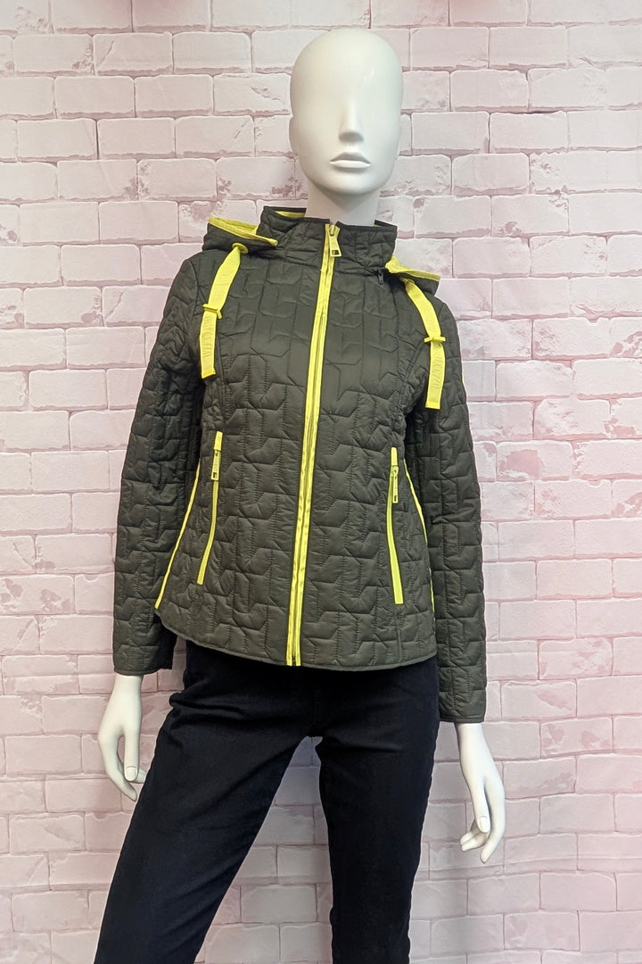 An olive green quilted hooded jacket with bright yellow zippers and drawstrings, displayed on a white mannequin against a pink brick wall background.