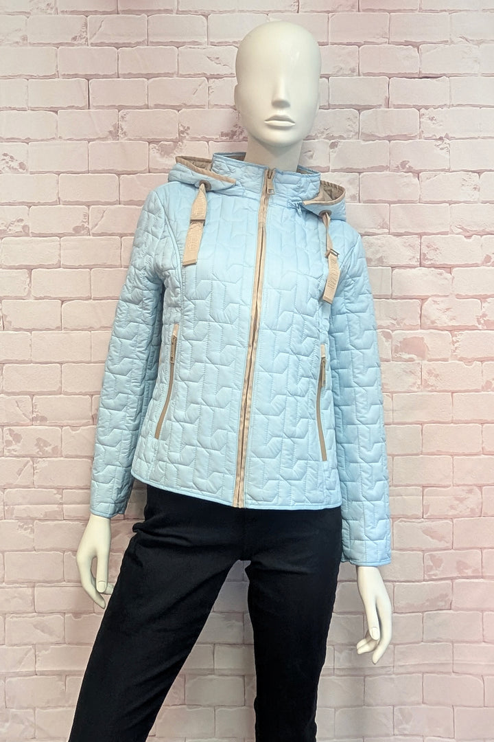 A light blue quilted hooded jacket with beige drawstrings and zipper trim, displayed on a white mannequin wearing black pants against a pink brick wall background.