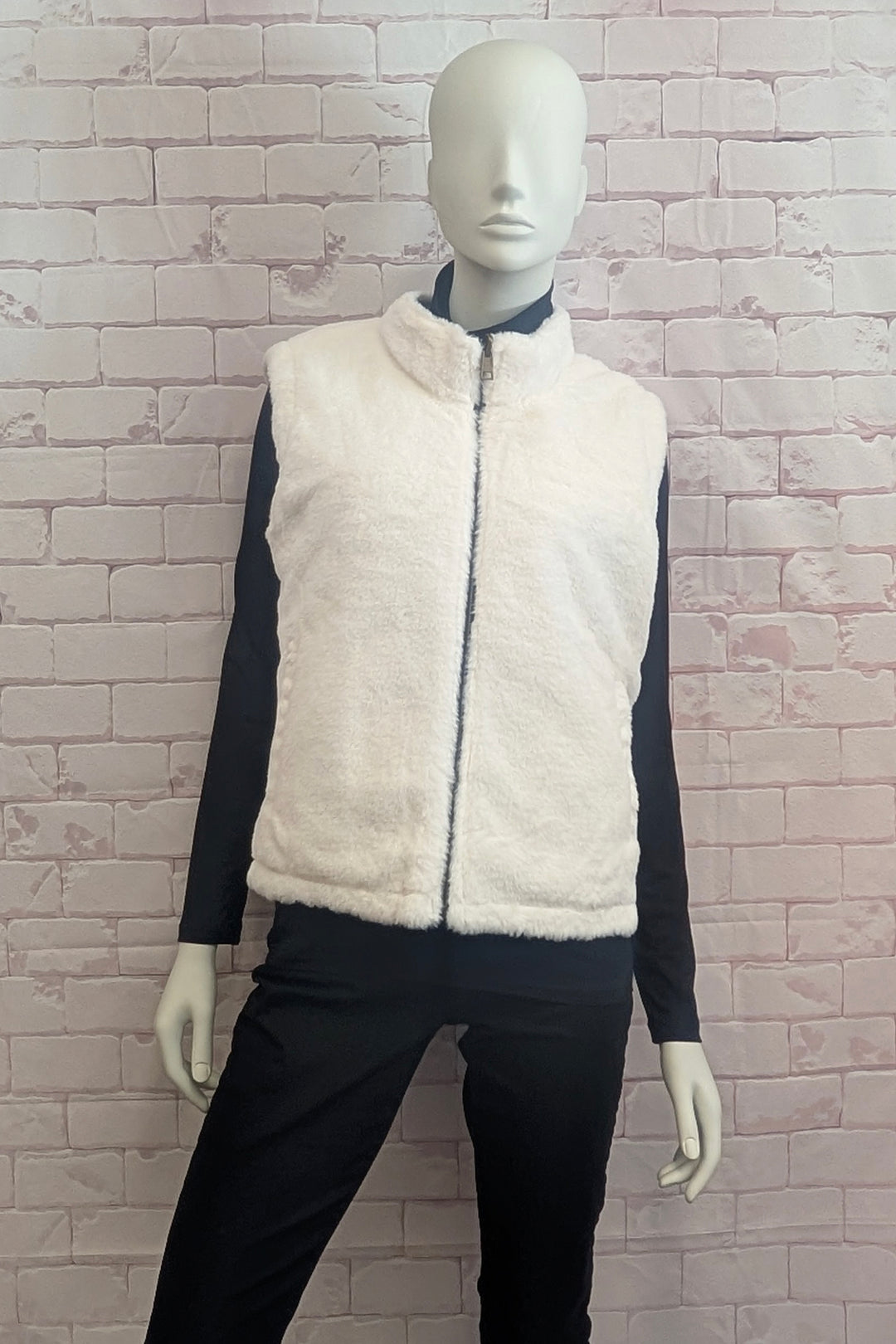 A mannequin modelling a faux fur sleeveless zip-front vest with a high stand-up collar