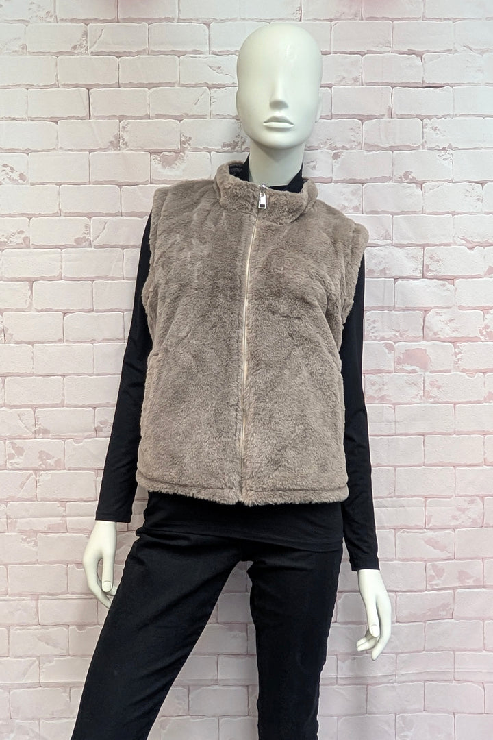A mannequin wearing a sleeveless faux fur vest with a high collar