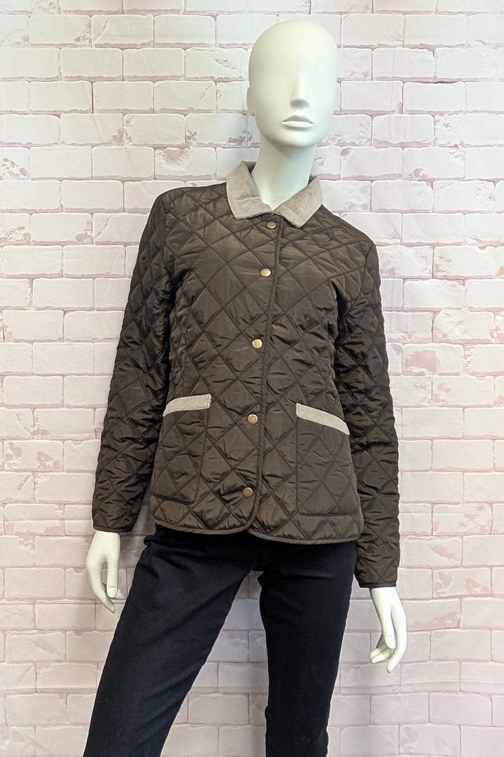 Mannequin wearing a quilted jacket in dark brown with a contrasting beige fleece collar and matching beige trim on the pockets, featuring gold-tone buttons.