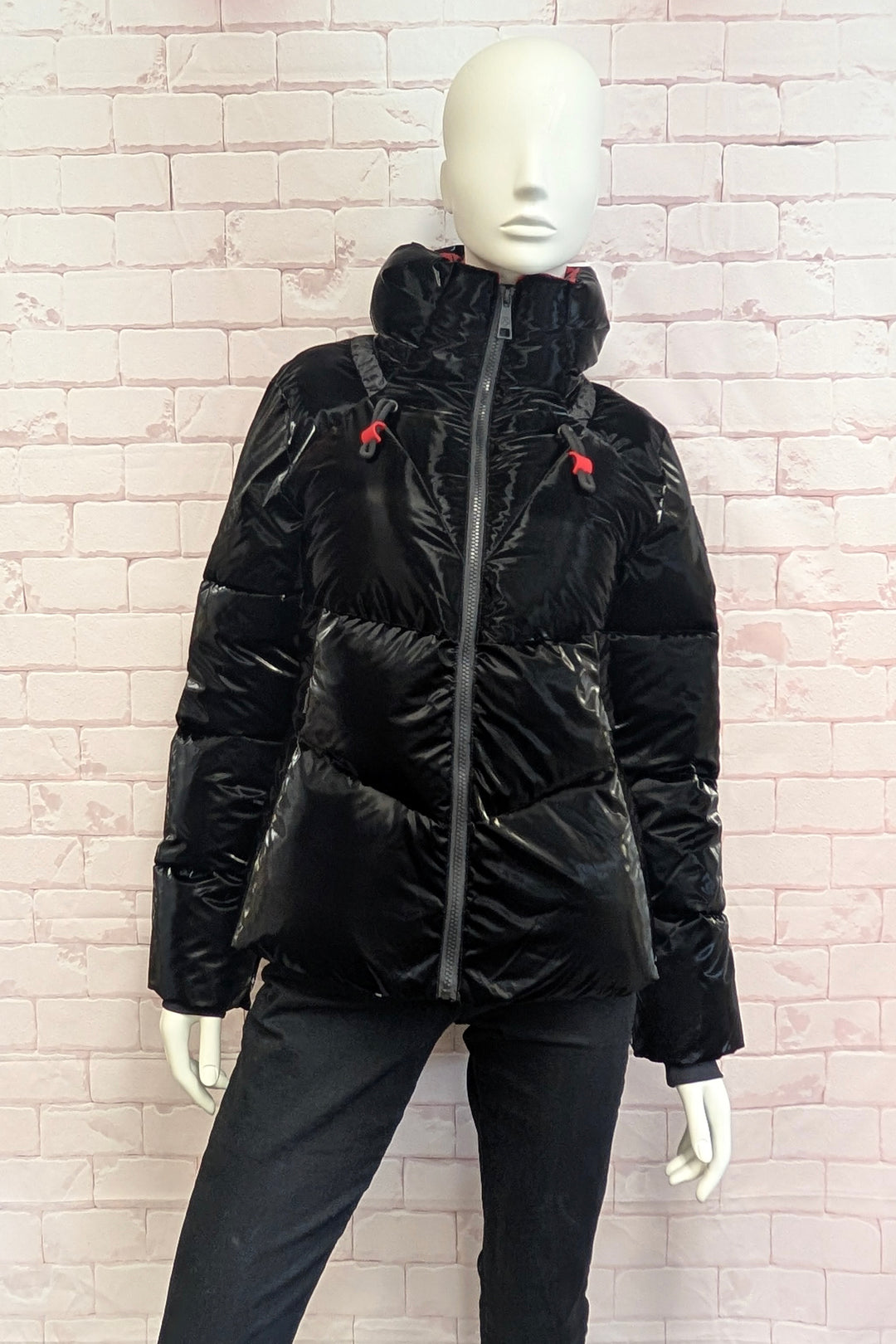 A mannequin wearing a A black puffer jacket with horizontal quilting and a hood