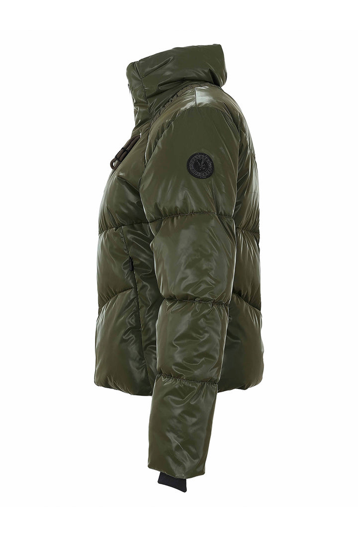 An olive green puffer jacket shown from a side profile view against a plain white background. The jacket features horizontal quilting, a high collar, and a circular black logo patch on the upper left sleeve.