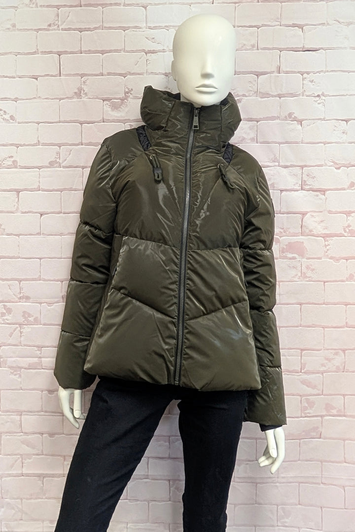 A mannequin wearing a olive green puffer jacket with a hood, front zipper, and drawstring details.