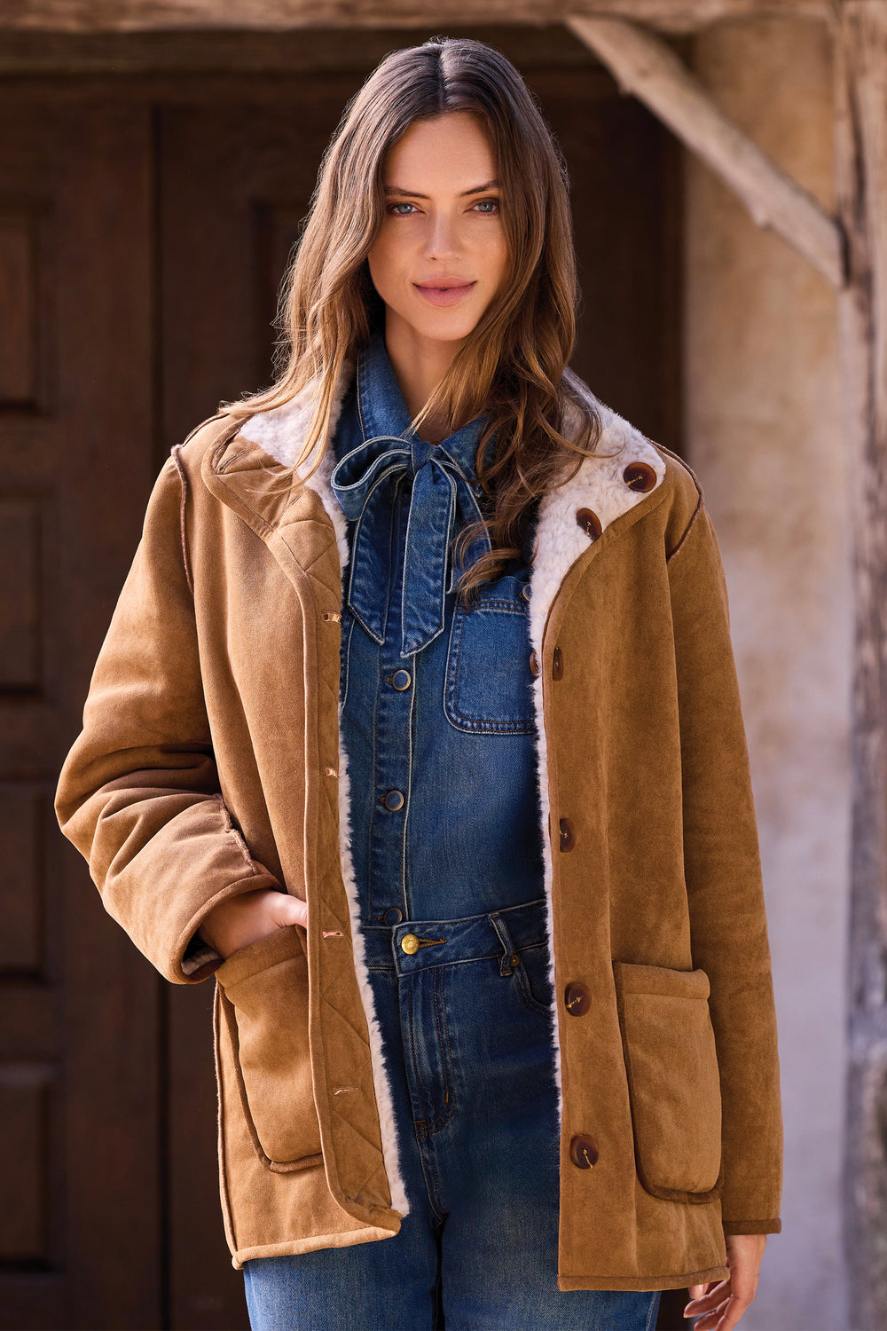 A woman wearing a reversible faux fur and sherpa jacket. 