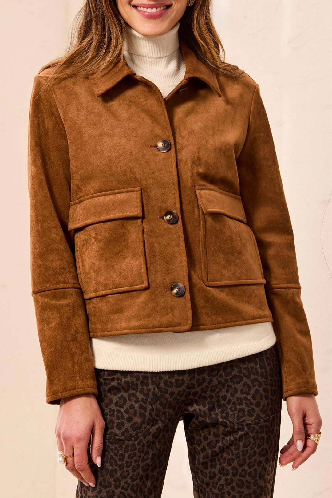 A woman wearing a boxy faux suede jacket with large front pockets. 