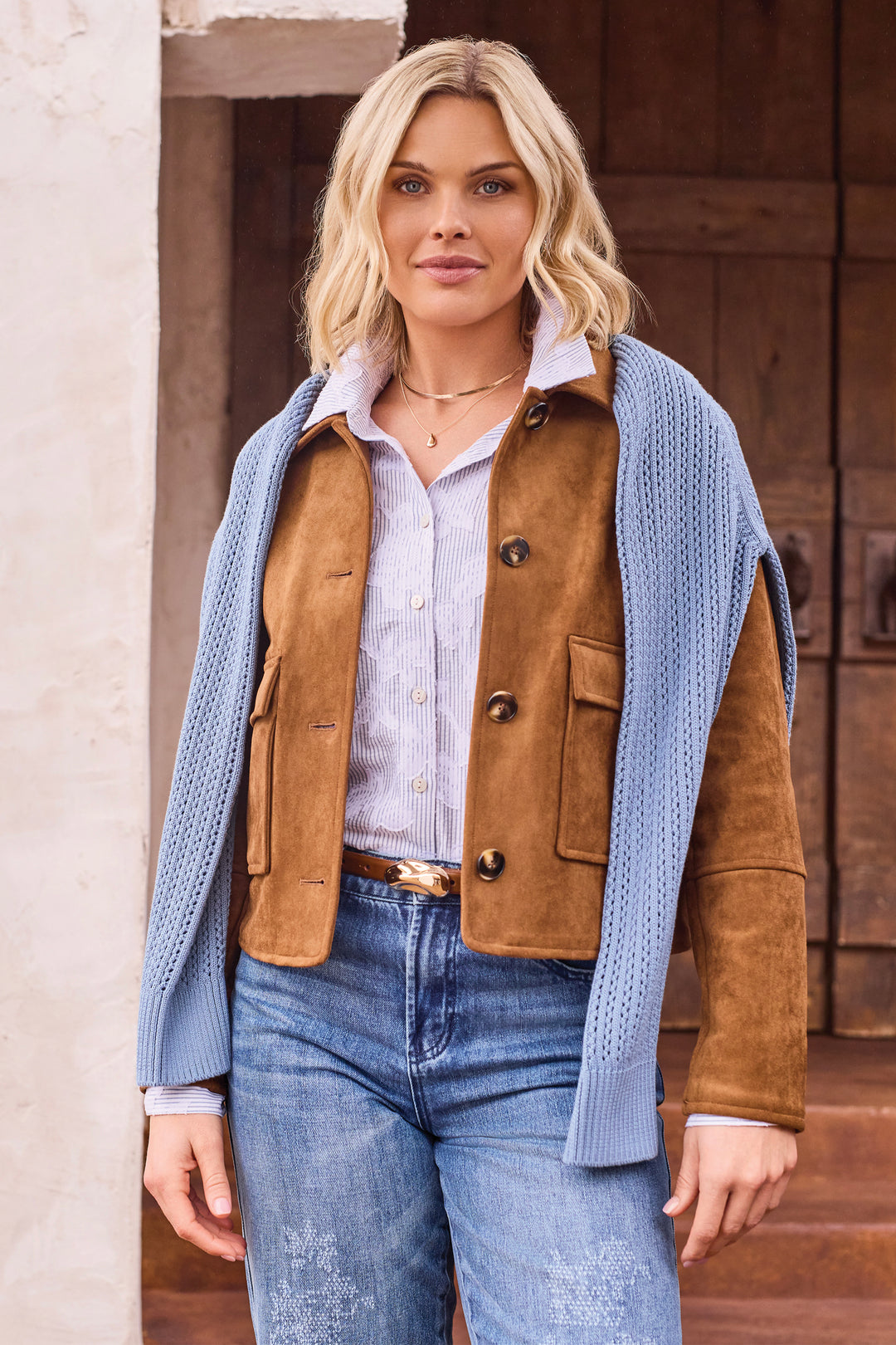A woman wearing a boxy faux suede jacket with large front pockets. 
