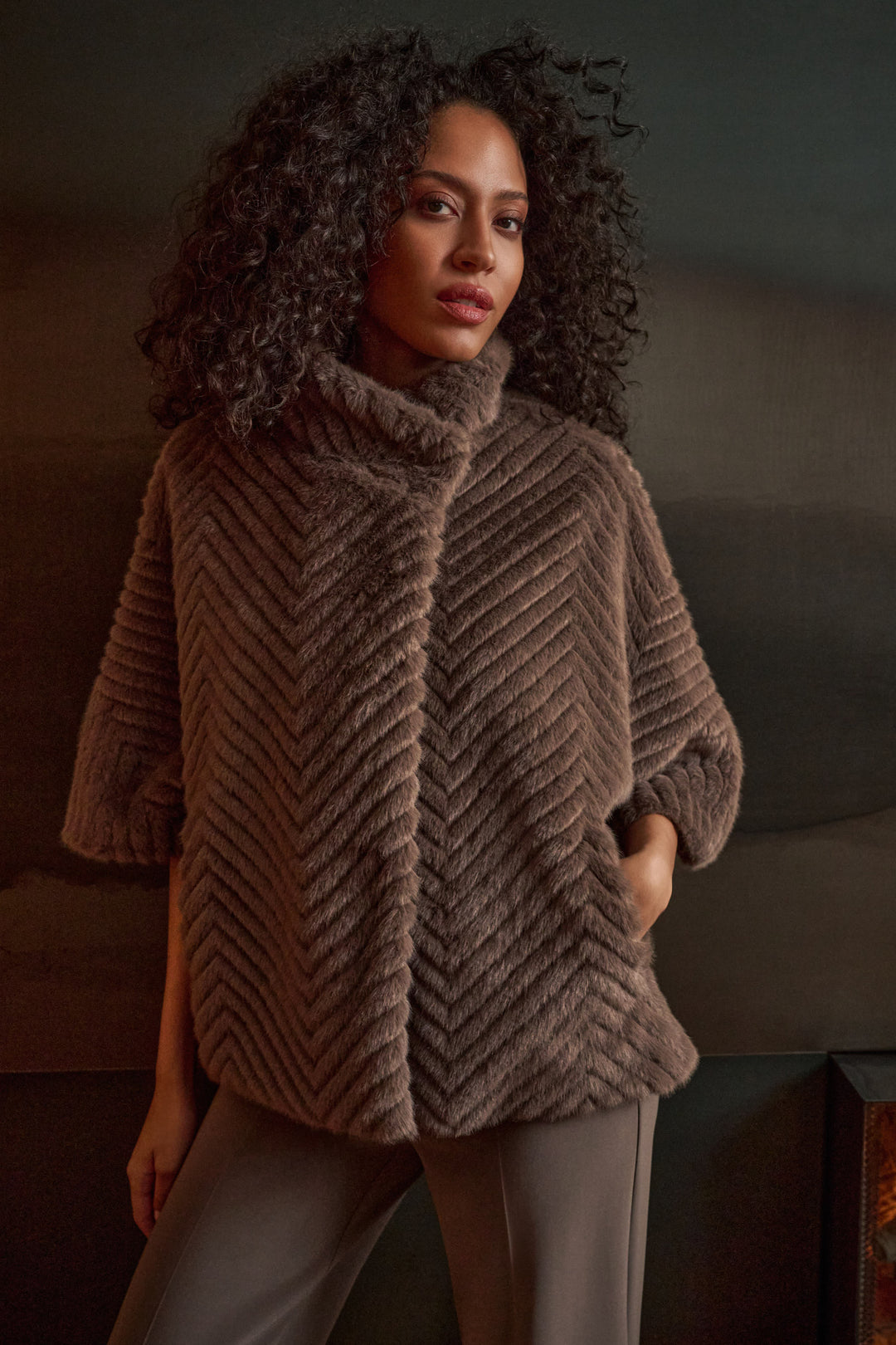 A woman wearing a brown faux fur cape jacket.