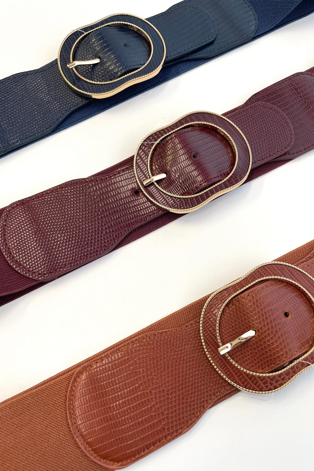 Crafted from faux leather and a stretch fabric, this belt features a gold lined buckle, allowing you to adjust and customize the fit for a secure and comfortable wear.