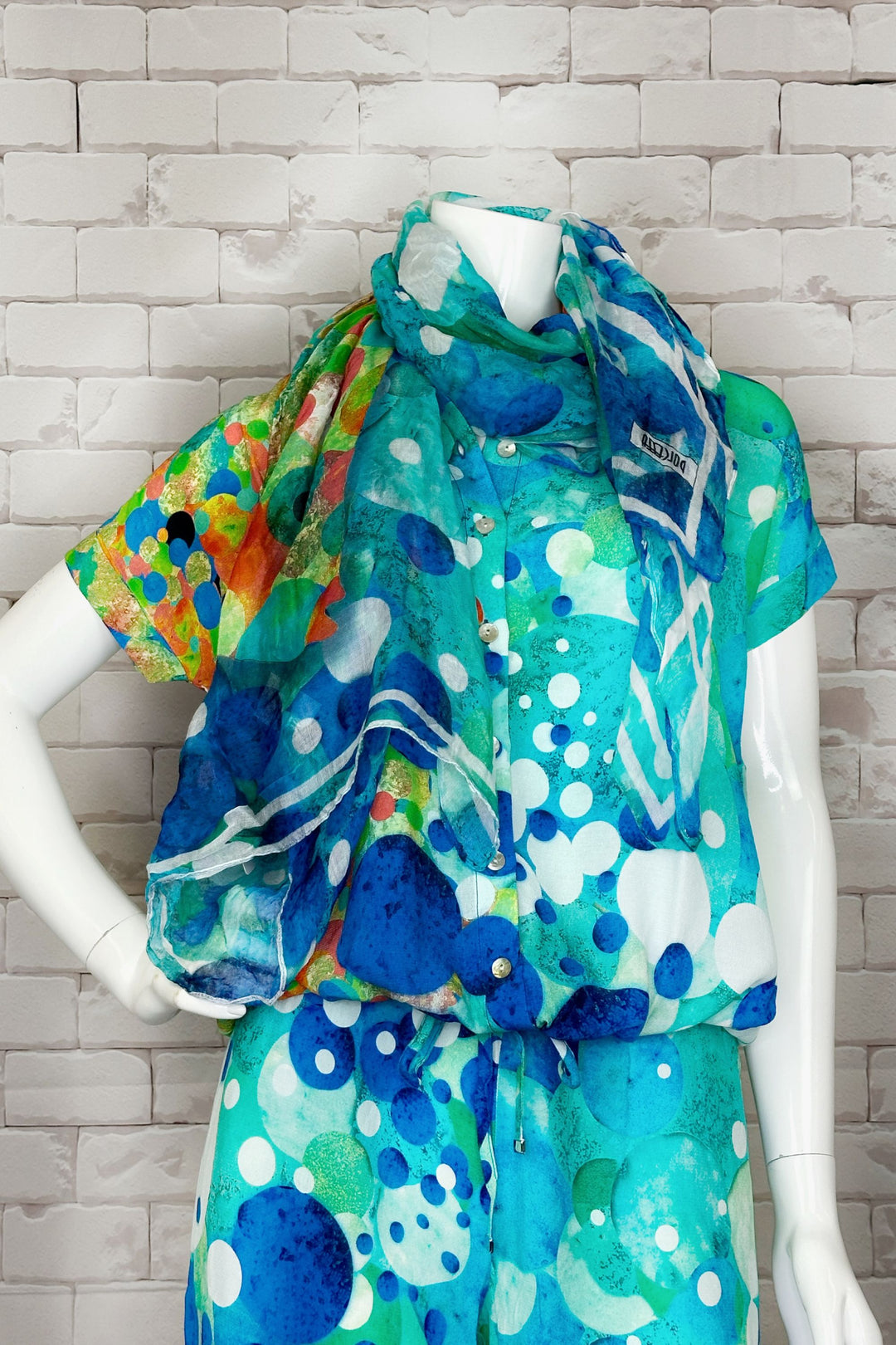 This light and lovely woven scarf features a colourful abstract print that pairs perfectly with all your summer Dolcezza favourites! 