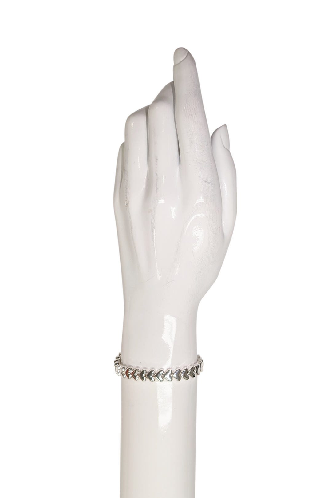 Silver hearts bracelet on a wrist on a  white backdrop 