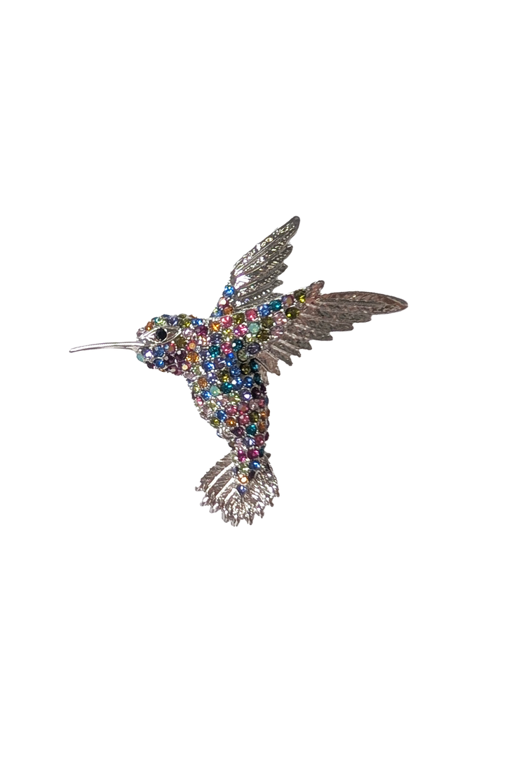 Decorative hummingbird brooch with multicolored gemstones on a white background