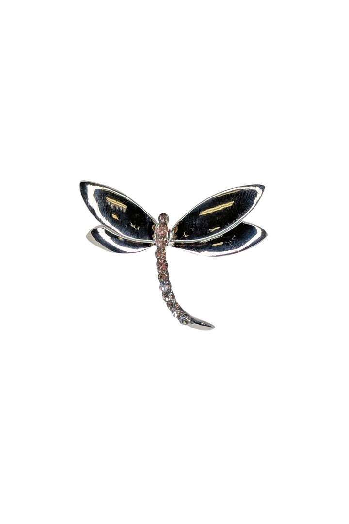 Dragonfly-shaped brooch with black and gold details on a white background