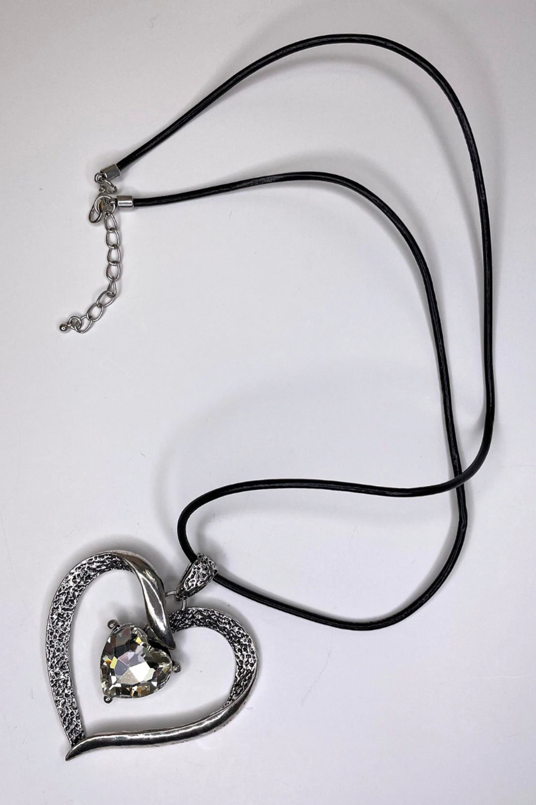 Featuring a sparkling silver crystal heart with a hanging pendant piece on an adjustable cord, this necklace will bring a touch of elegance to any look.