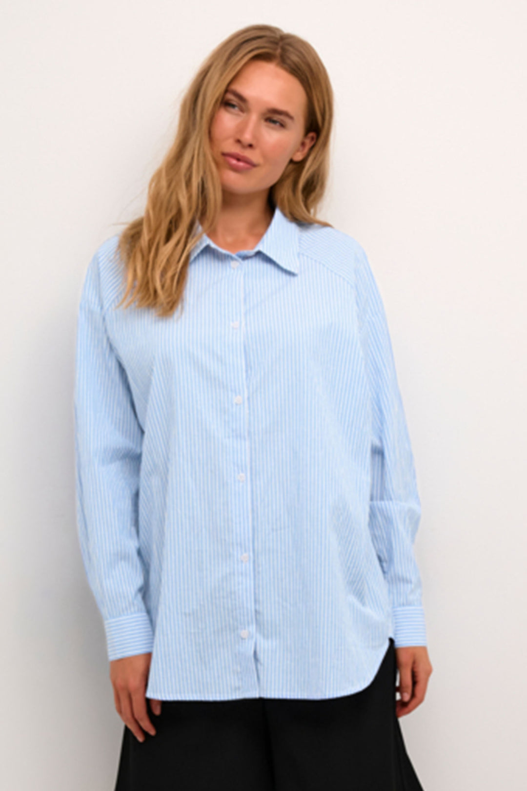 Kaffe Summer 2024 This classic all-cotton shirt features a relaxed fit, perfect for a casual look. Roll up the sleeves and show off the subtle thin white pinstripes, giving it a classy touch. 