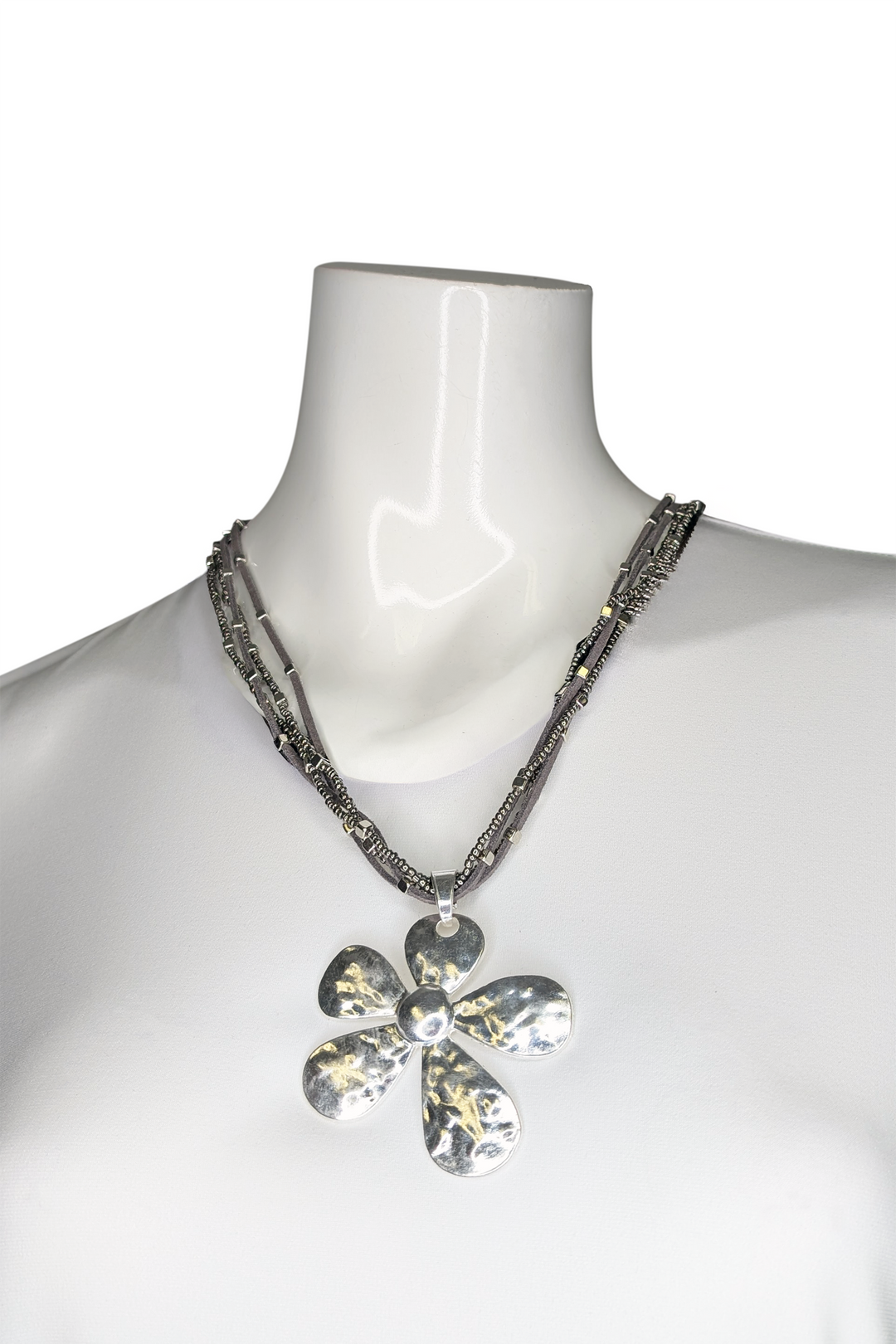 Necklace with a silver flower pendant on a mannequin against a white background