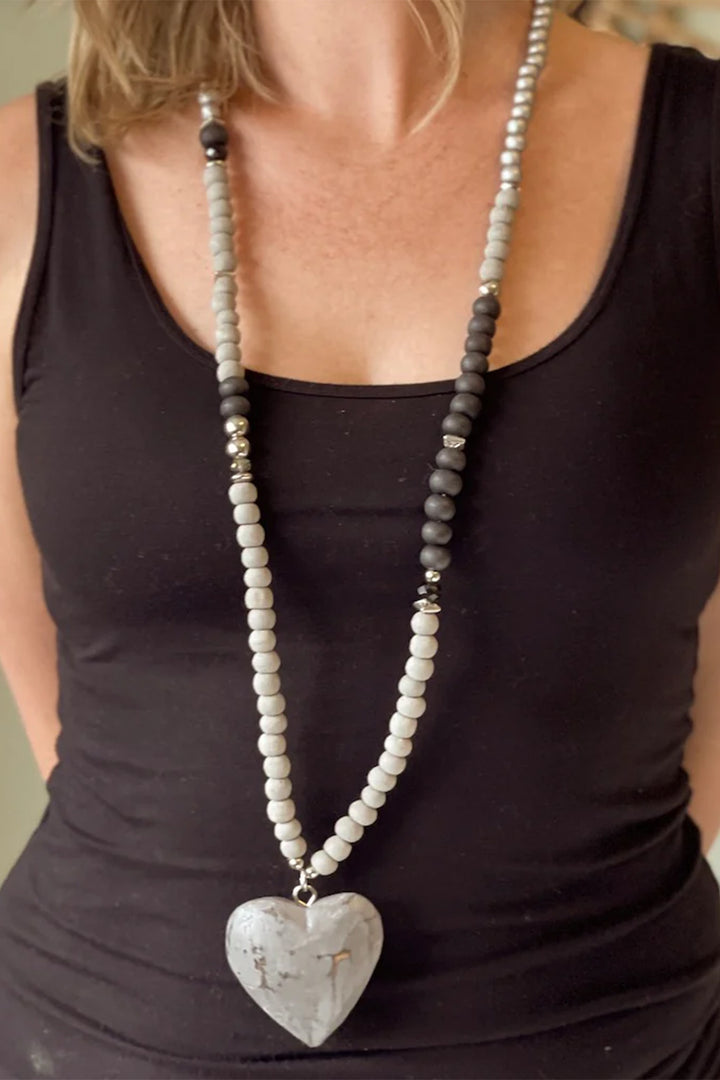 SUZIE BLUE Fall 2025 
Handcrafted with care, this wooden heart necklace combines natural charm with versatile style. Each piece features delicate beads and a beautifully carved wooden heart that pairs effortlessly with any outfit.