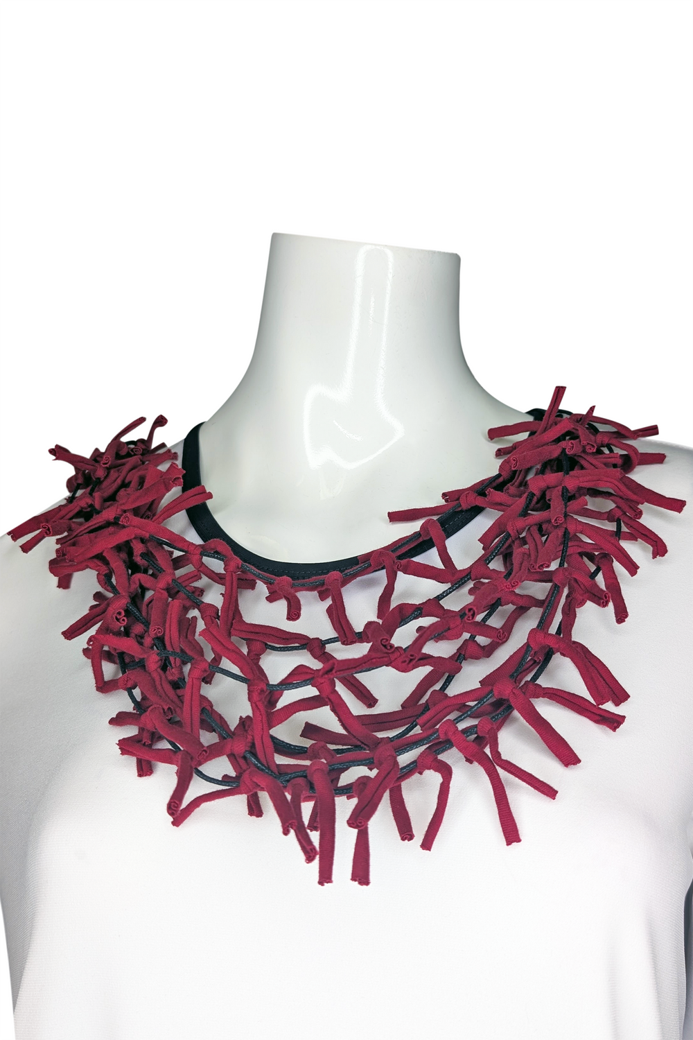 Red ribbon necklace on a mannequin against a white background