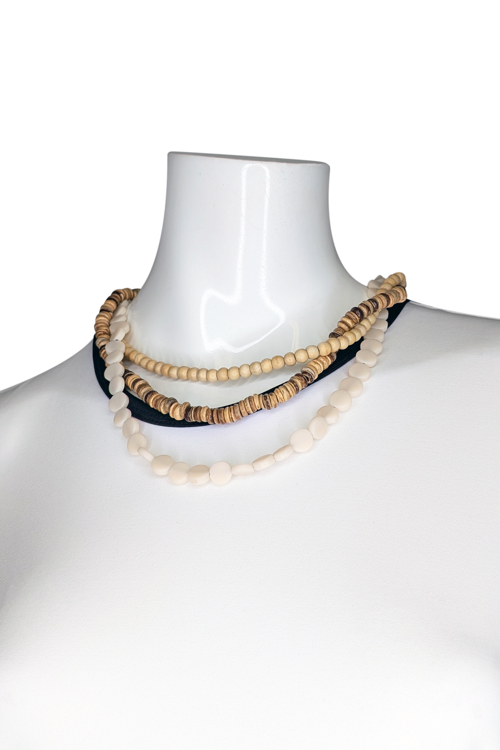 Necklace with wooden beads on a mannequin against a white background