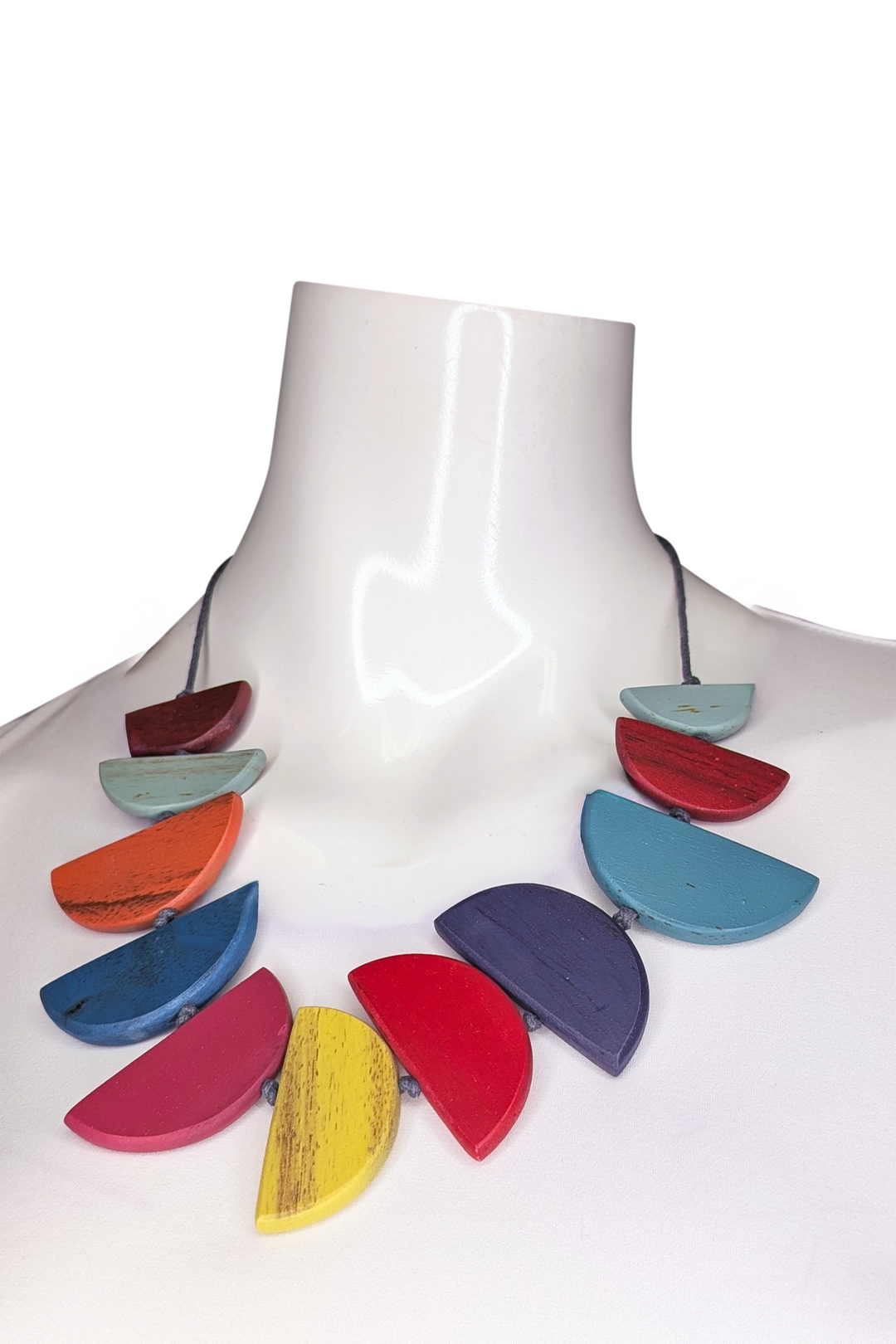 Colorful necklace on a mannequin against a white background