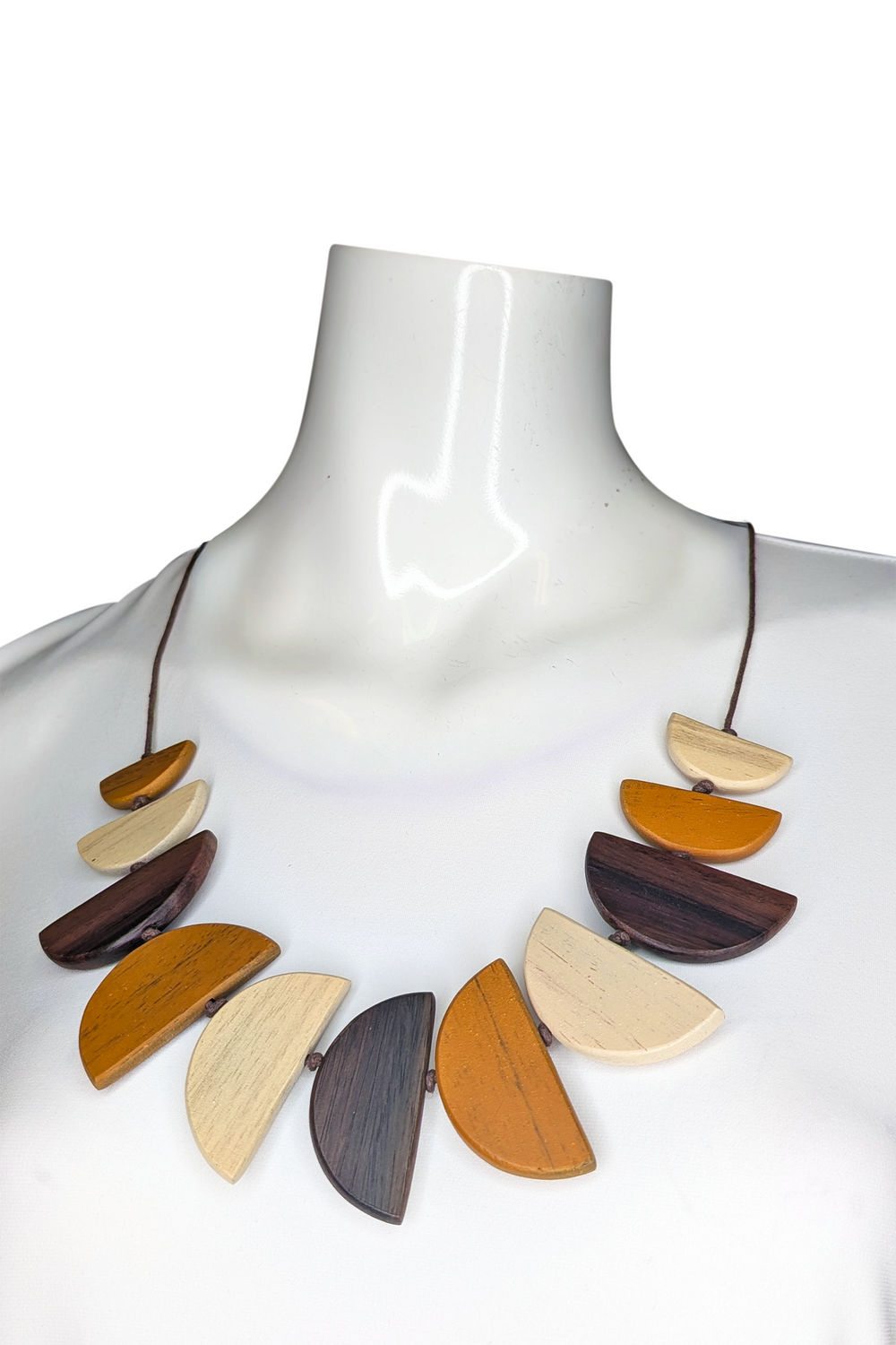 Necklace with wooden pendants on a mannequin against a white background