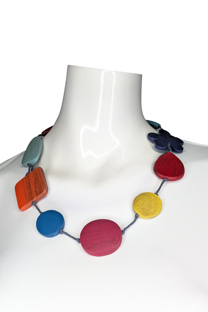 Colorful necklace on a mannequin against a white background