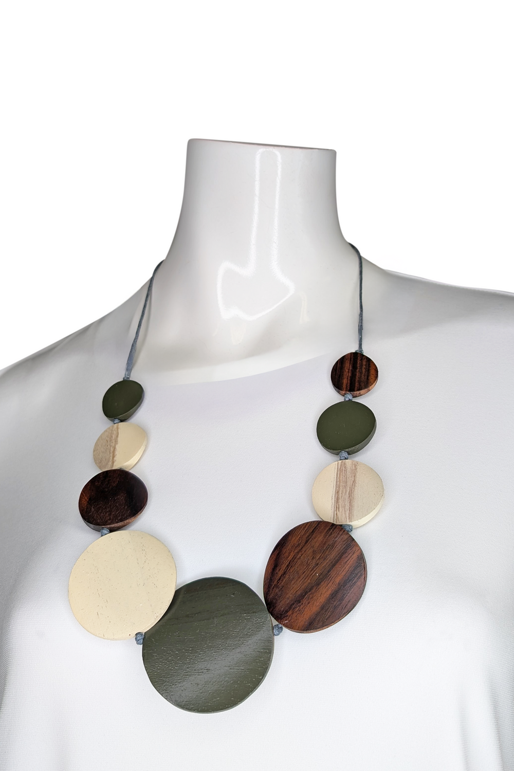 Necklace with wooden beads on a mannequin against a white background
