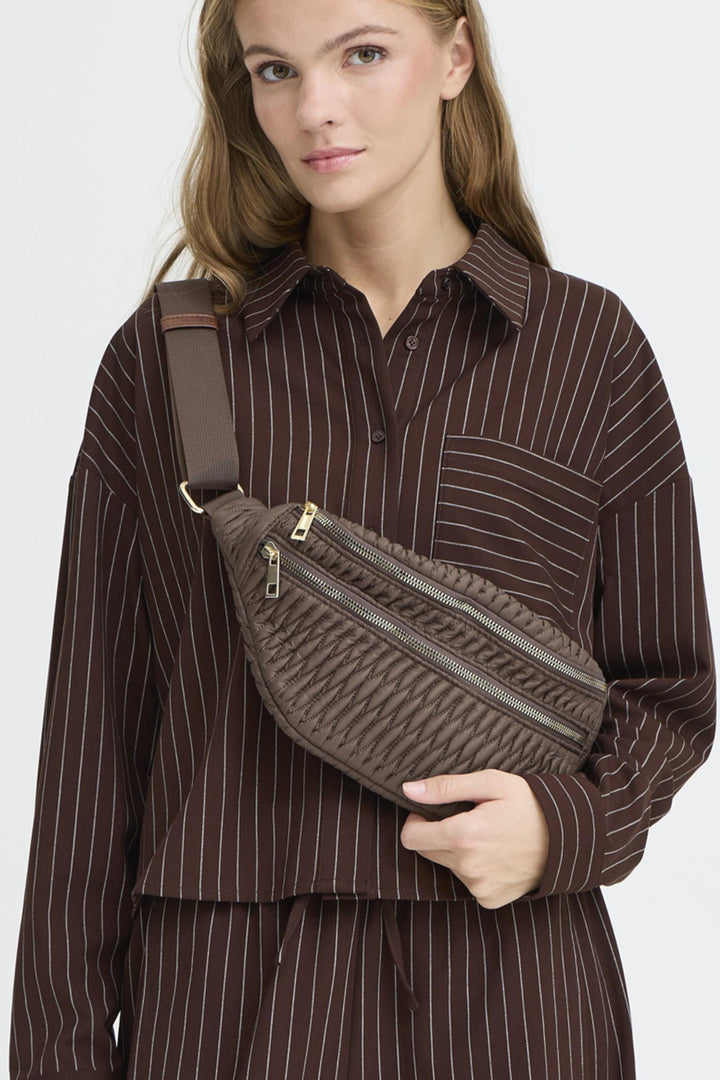 ICHI Fall 2025 
It comes with an adjustable belt strap to ensure a comfortable fit. Two zip compartments provide organized storage, keeping your essentials secure and easily accessible.