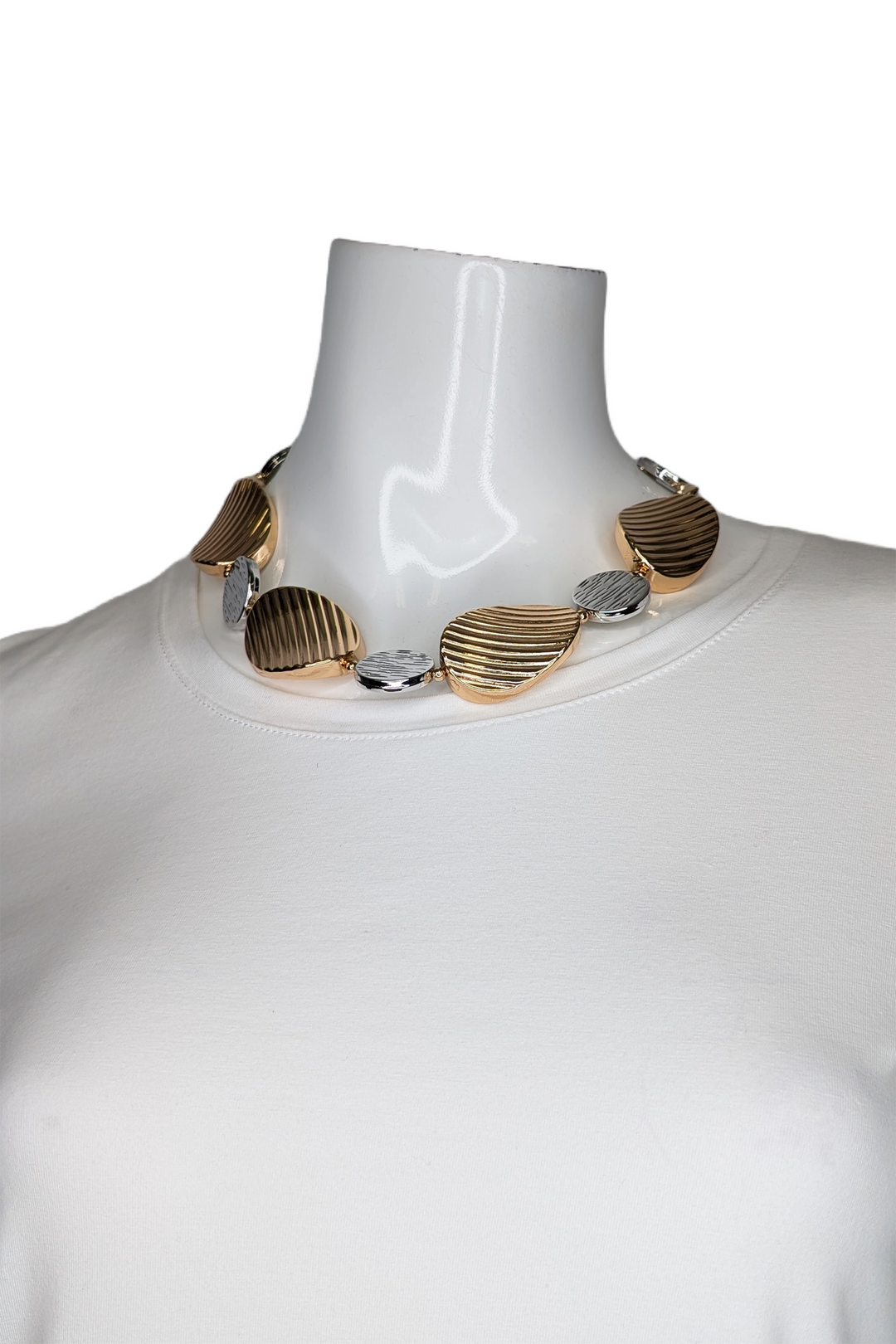 Mannequin wearing a necklace with gold and silver accents on a white background