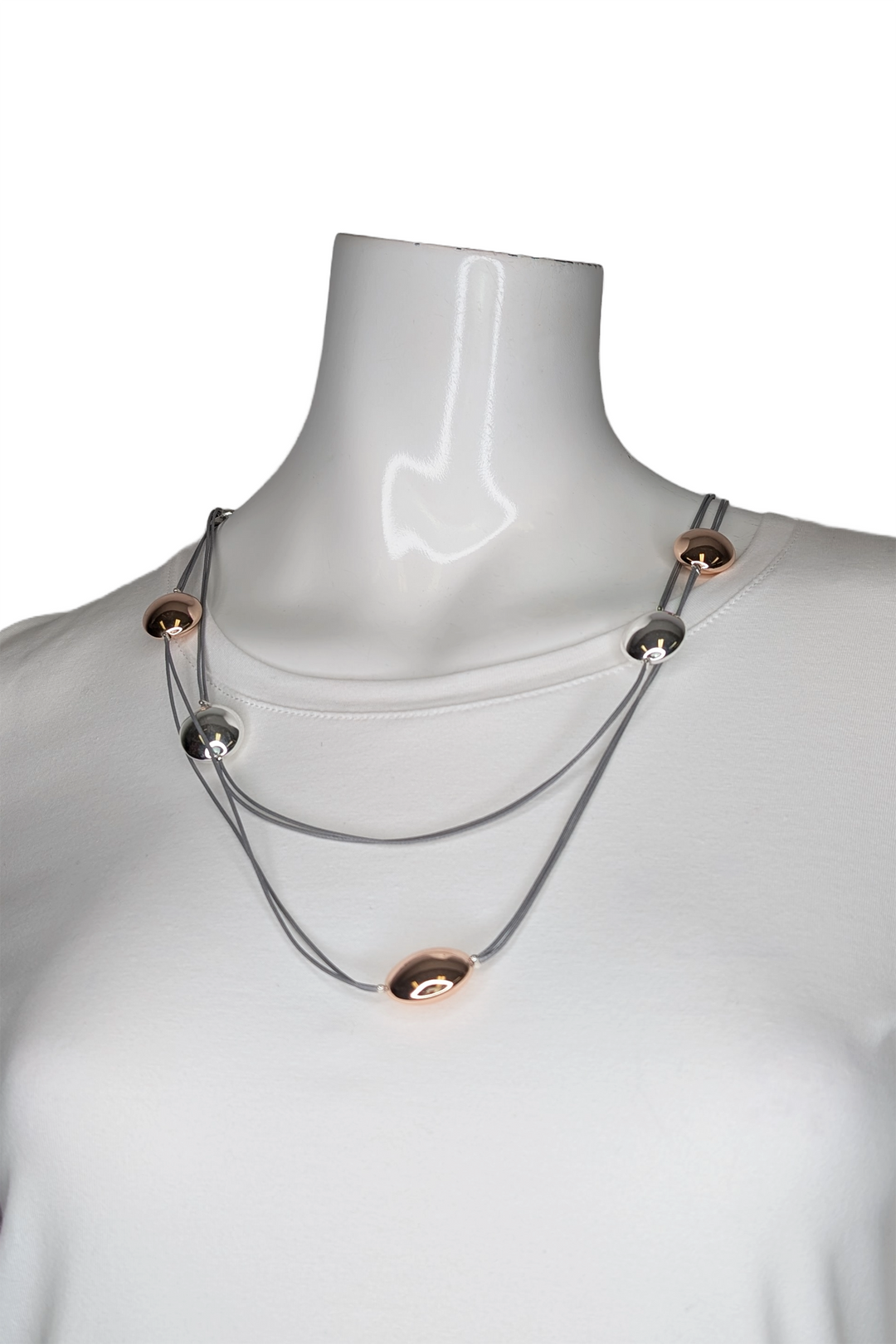 Necklace with silver and rose beads on a mannequin with a white background