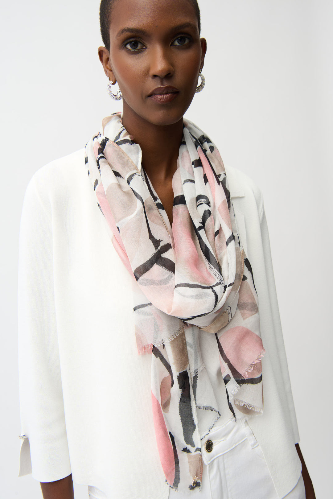 Woman wearing a colorful light scarf with abstract patterns on a white background