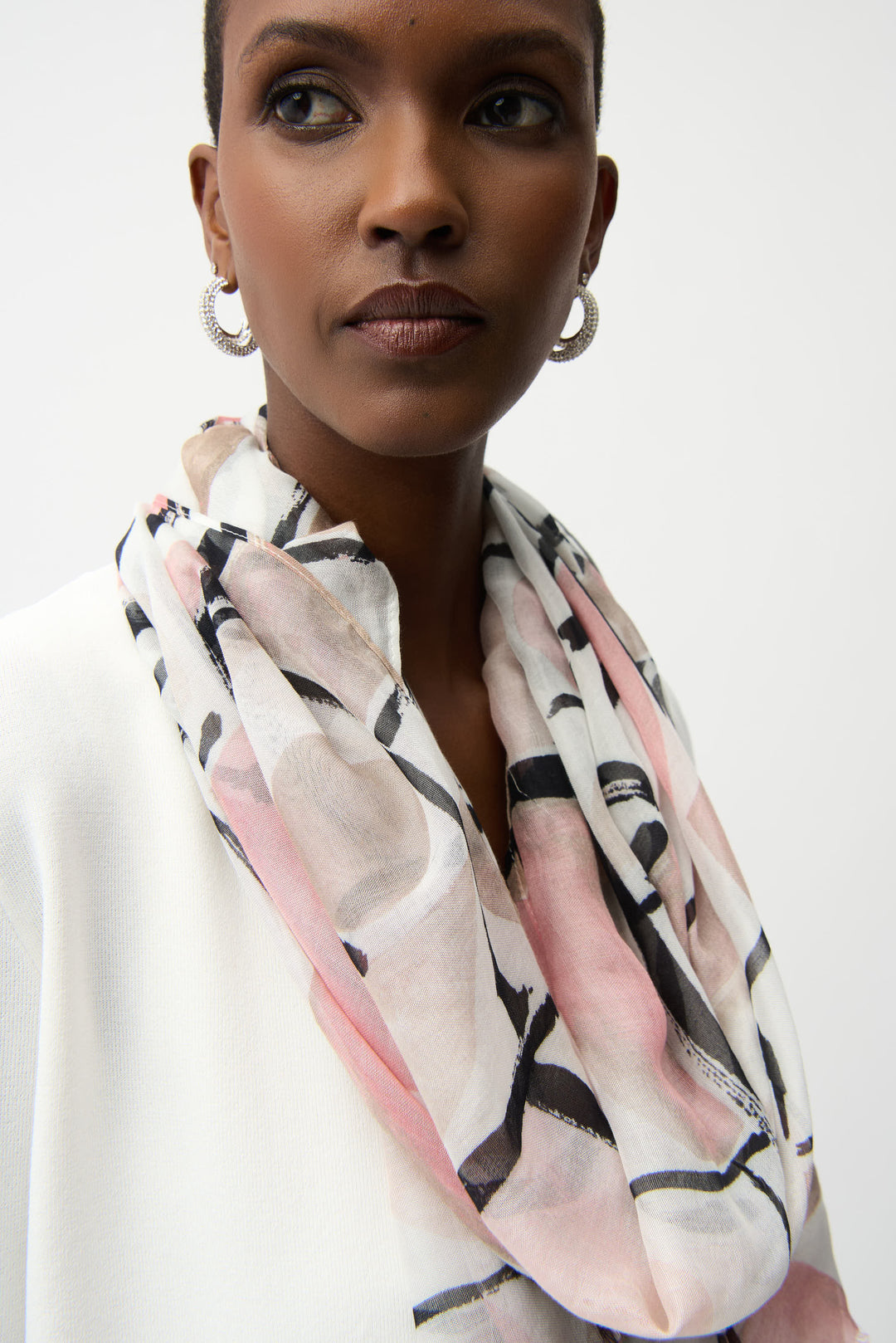 Woman wearing a patterned scarf on a white background